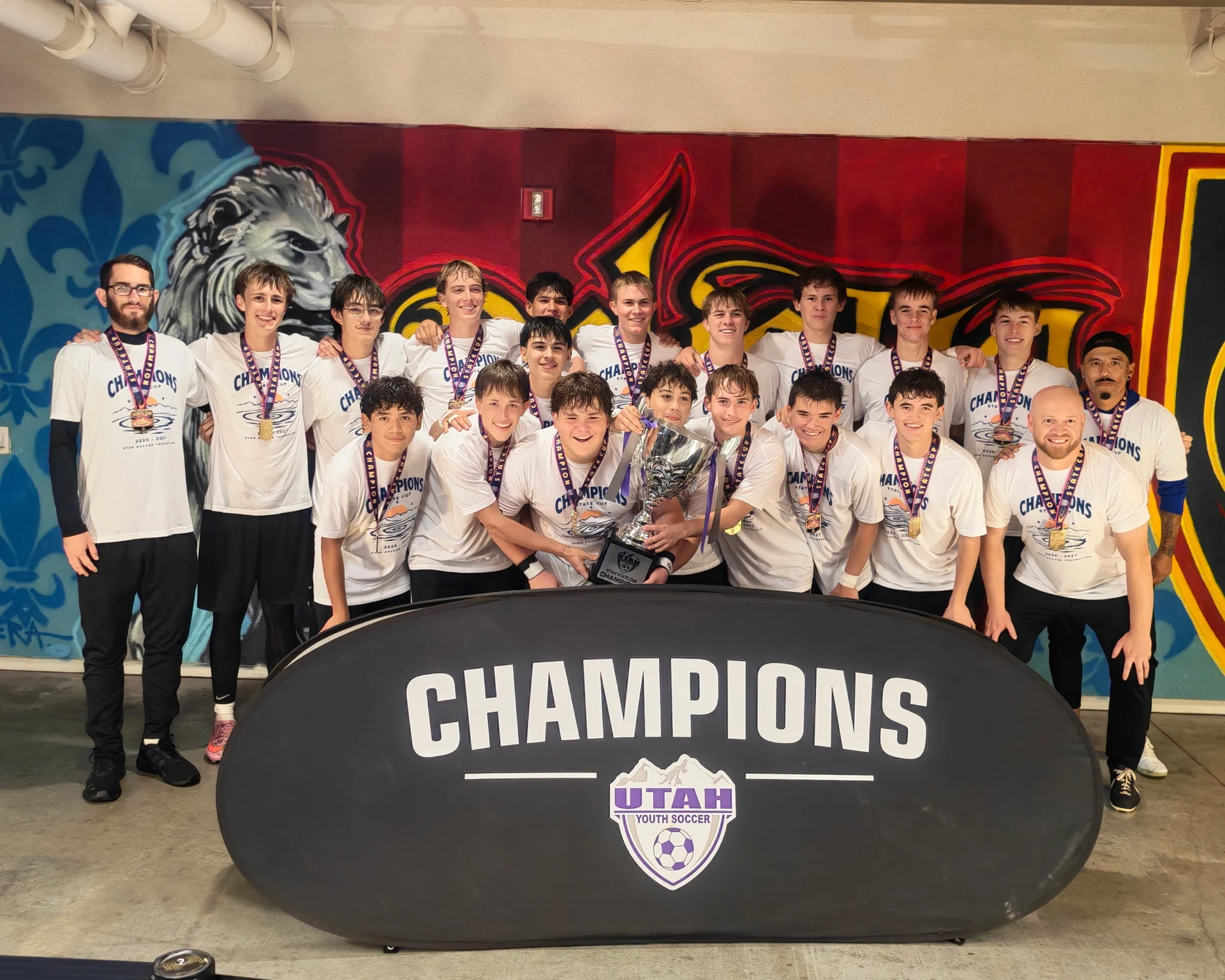 Fire FC boys and coaches celebrate with their State Cup trophy.